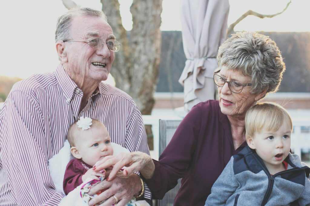 pexels photo 302083 302083 Grandparents spending joyful moments with their grandchildren in an outdoor setting, captured candidly.